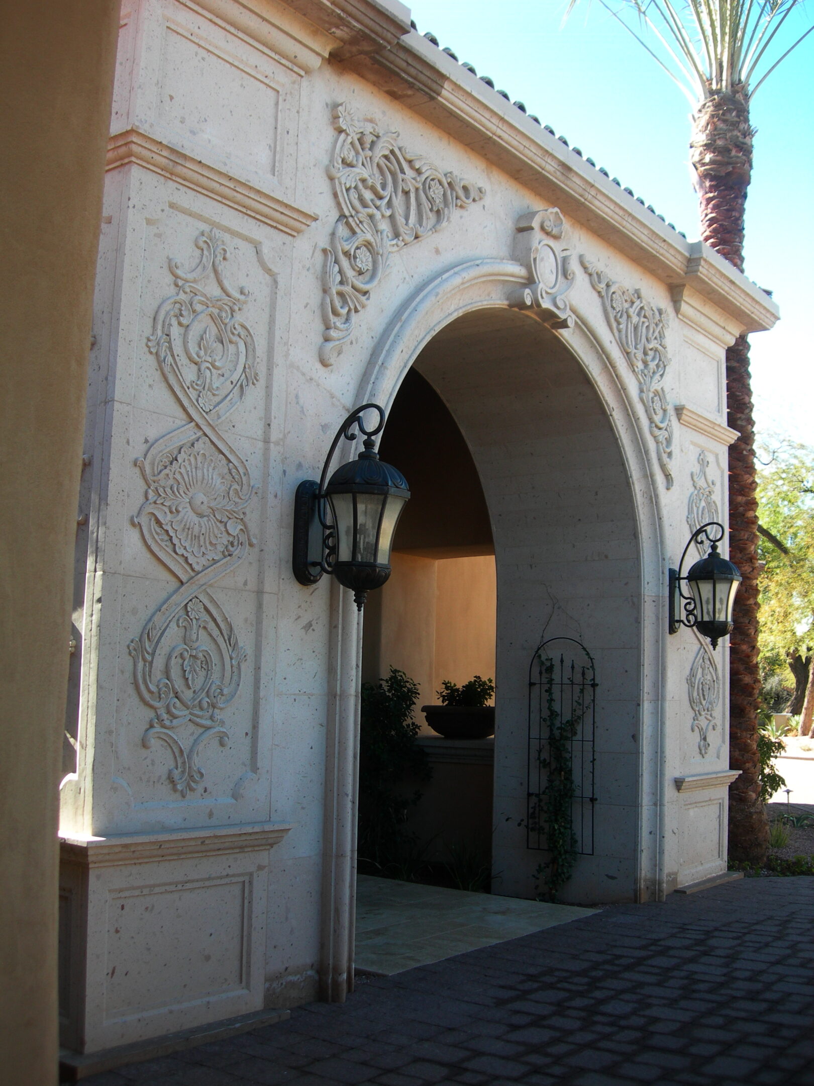 A white archway with an ornate design on it.