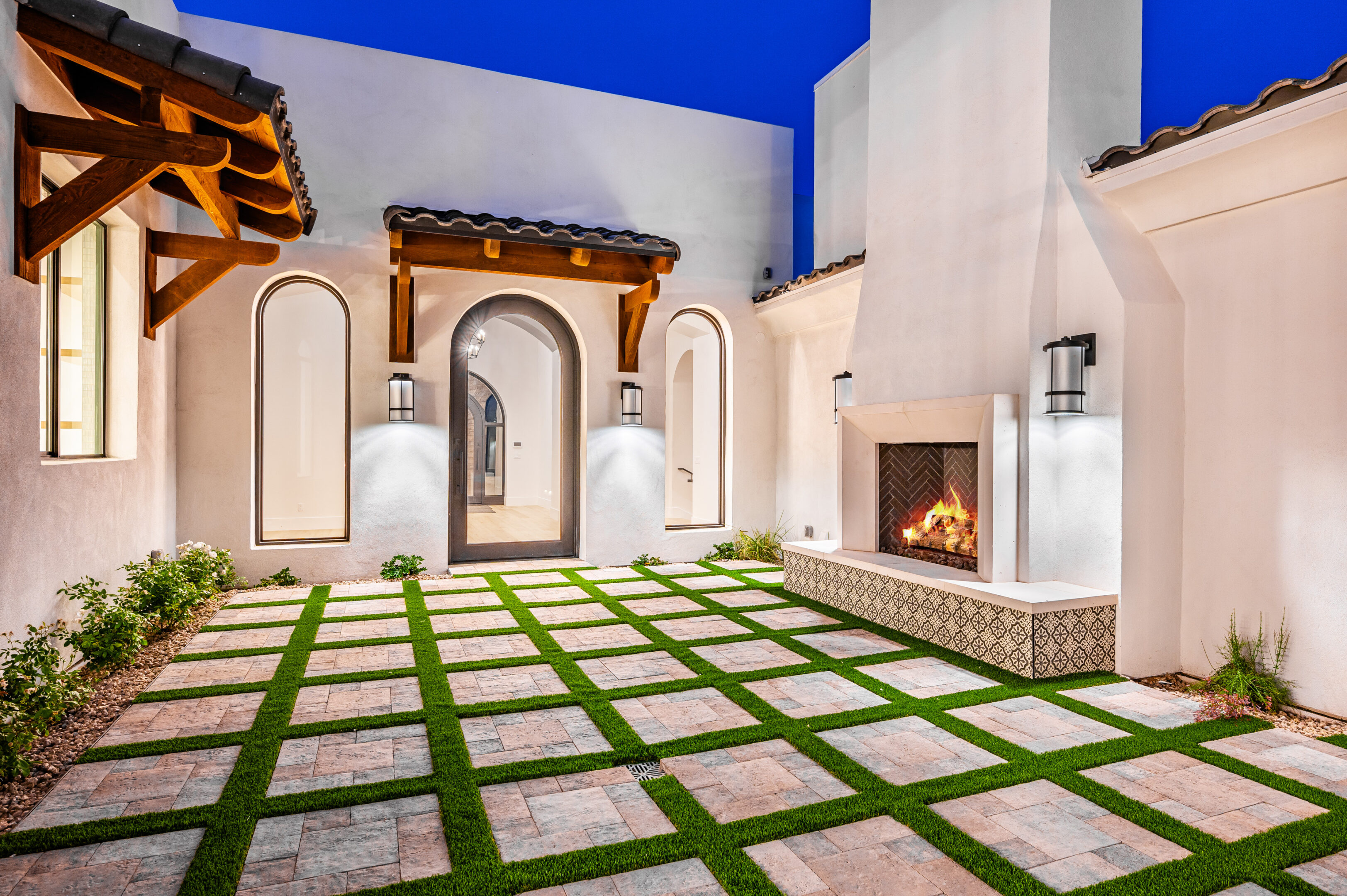 A large patio with grass and fire place