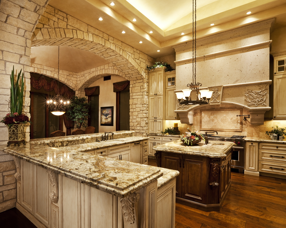 A kitchen with marble counters and stone walls.