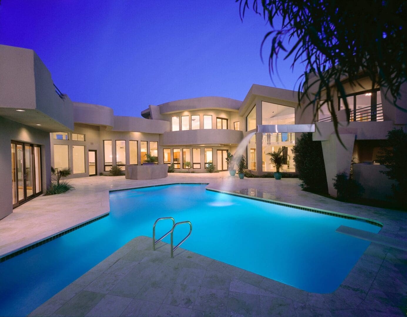 A large swimming pool in front of a house.
